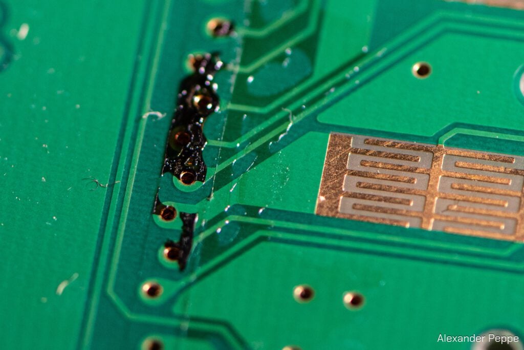 A closeup of a soda spill on the vias. Exposed Yamaha contacts can be seen mere millimeters away.