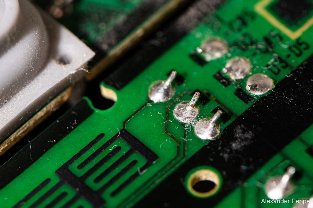 A closeup of a Yamaha contact from another angle. Here, you can see pocking in the trace underneath the surface of the circuit board. A little bit of a rust on a solder joint stands out like a flag to help locate the damage.